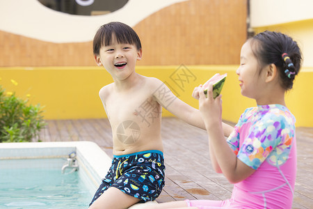 小朋友坐在泳池边吃西瓜玩耍度假高清图片素材