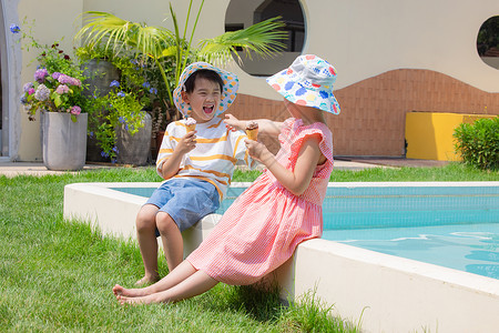 小男孩小女孩手拿冰淇淋坐在泳池边玩耍暑假高清图片素材