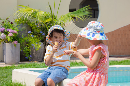 小男孩小女孩手拿冰淇淋坐在泳池边玩耍两小无猜高清图片素材