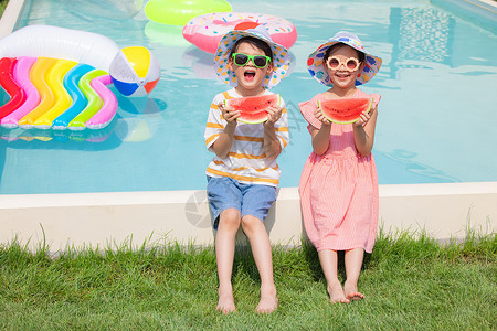 小男孩和小女孩坐在泳池手捧西瓜高清图片