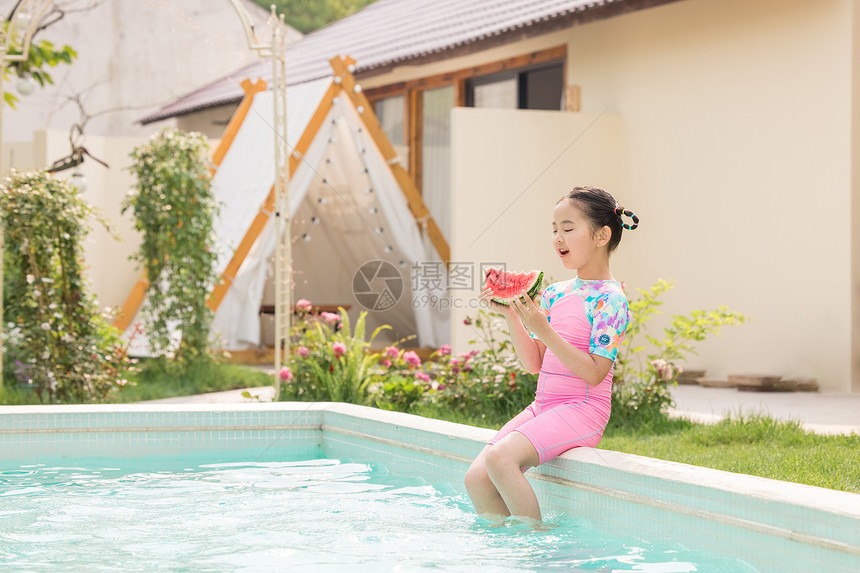 小女孩拿着西瓜坐在泳池边图片
