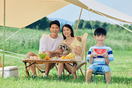 西瓜里小孩夏天幸福一家人带着宠物户外露营背景