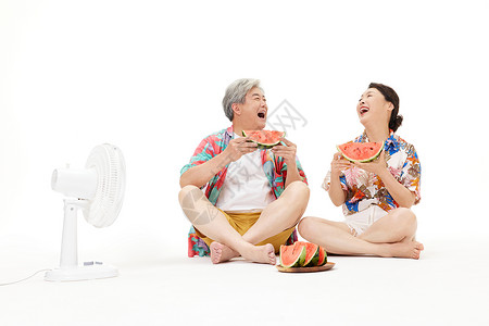 吹风扇乘凉的老年夫妻吃西瓜背景图片