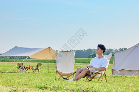 毕业旅行暑假年轻男士享受户外露营度假时光背景