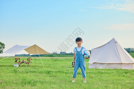 小男孩户外草坪上抱着足球夏天高清图片素材