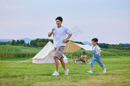 小男孩和爸爸在草坪上追逐打闹图片素材