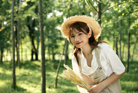 夕阳下手拿麦穗的夏日清新美女图片