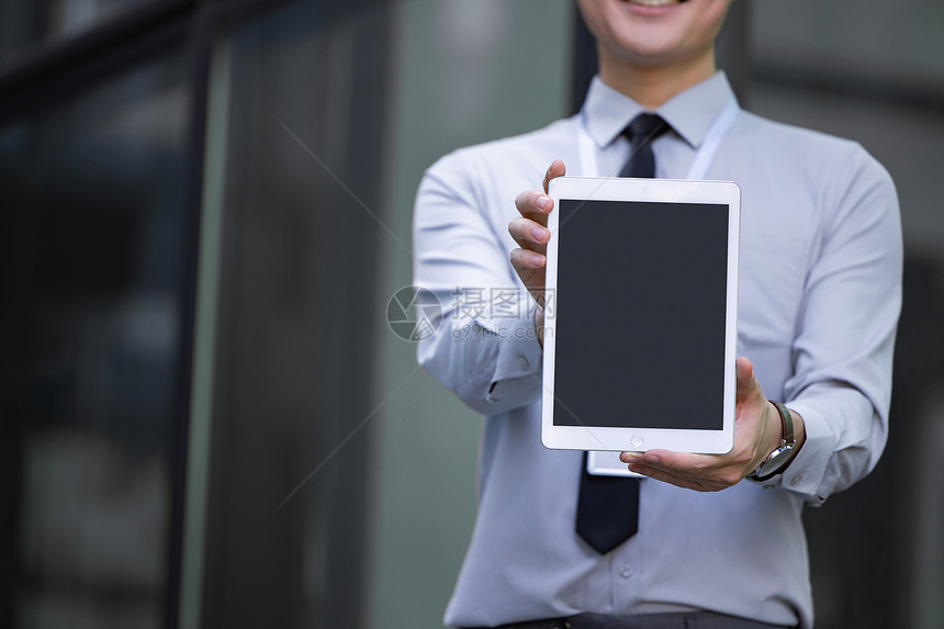 职场男性在室外双手展示平板电脑图片