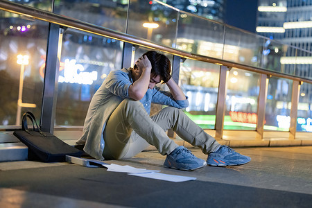 失恋男人难过的男性青年双手抱头背景