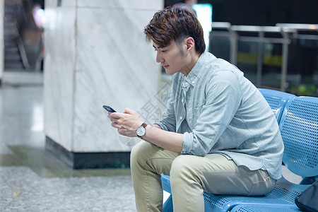 年轻男性坐在地铁站看手机代步工具高清图片素材