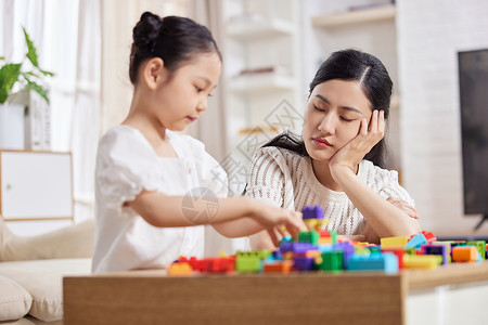 疲惫的妈妈在家陪伴女儿暑假高清图片素材