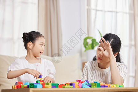 疲惫的妈妈在家陪伴女儿小孩高清图片素材