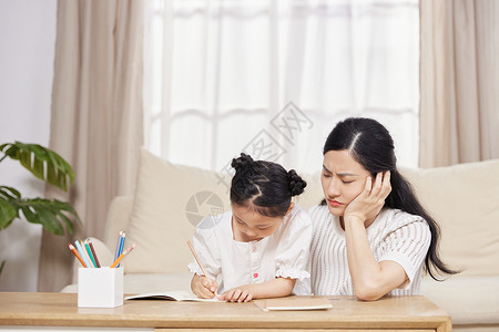 春困疲惫的母亲陪女儿做作业背景