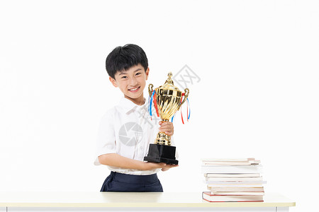 竞赛知识小男孩双手抱着奖杯背景