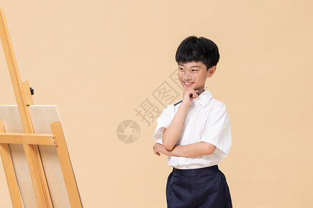 站在画板前绘画的小男孩兴趣高清图片素材