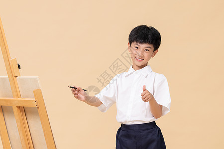站在画板前绘画的小男孩可爱高清图片素材