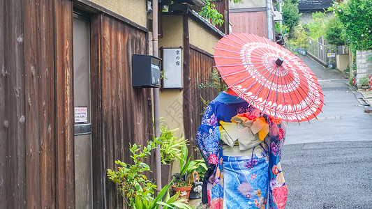 日本服装京都小巷里打伞的和服女孩背影背景