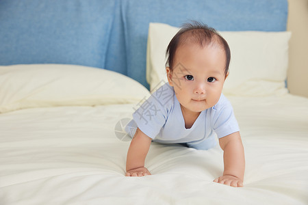 可爱婴幼儿宝宝床上爬行玩耍背景图片