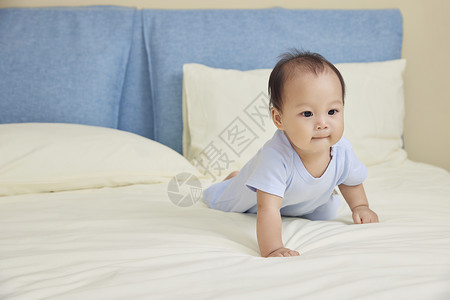 可爱婴幼儿宝宝床上爬行玩耍背景图片
