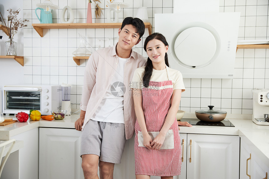 快乐的年轻情侣在厨房里准备做饭图片