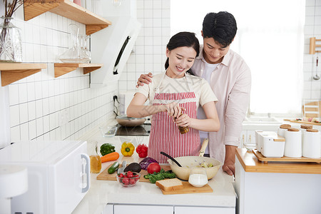 美女用餐快乐的年轻情侣在厨房里做轻食背景