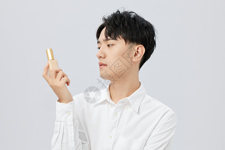 韩系男性手拿粉底液背景图片