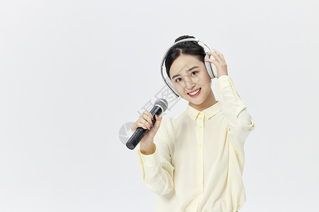 话筒耳机素材带着耳机唱歌的年轻女性背景