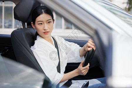 白天女性专车司机看右视镜倒车图片素材