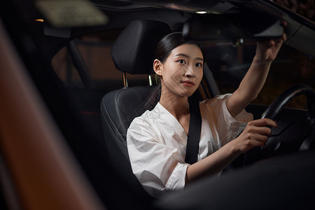白领女性司机夜间驾车检查后视镜服务高清图片素材