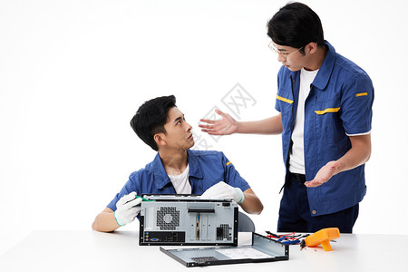 意见统一年轻的维修工在修电脑时意见不合背景