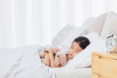 可爱儿童小女孩居家抱着玩偶熊睡觉背景图片