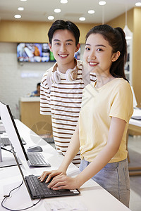 在数码产品店买电脑的大学生情侣图片