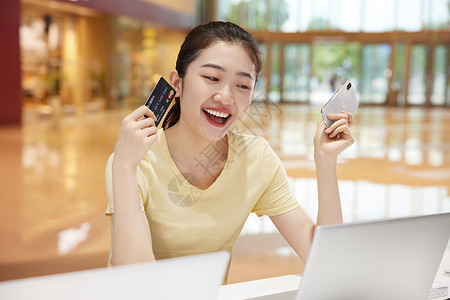 消费电子产品准备刷卡购买电脑的女大学生背景