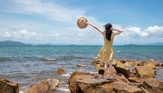 盛夏海边海边礁石上的少女背景