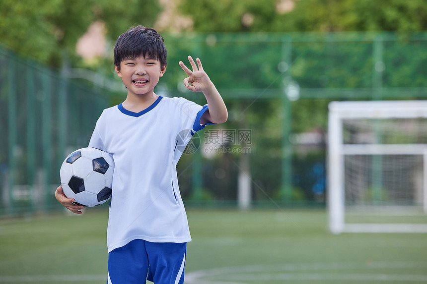 小男孩拿足球比OK手势图片