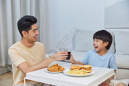 爸爸和儿子熬夜看电视吃宵夜图片