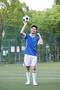 手举足球的男性图片