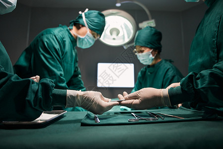 手术室医生做外科手术传递工具特写图片