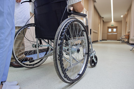 医院走廊护士推患者坐轮椅特写图片