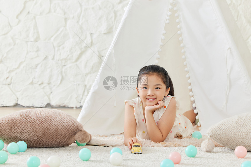 小女孩在儿童帐篷里玩汽车模型图片