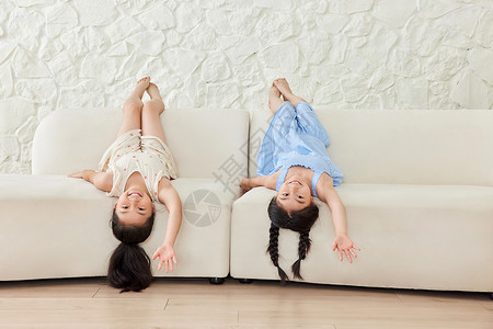 两个小女孩在沙发上玩耍背景图片