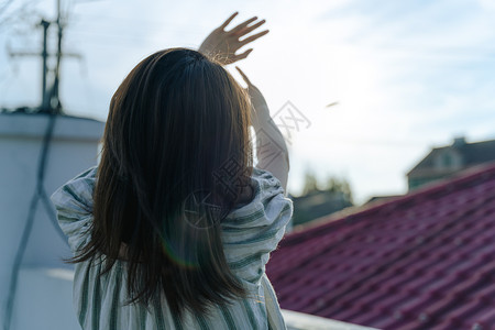 楼顶傍晚逆光的女孩背影图片