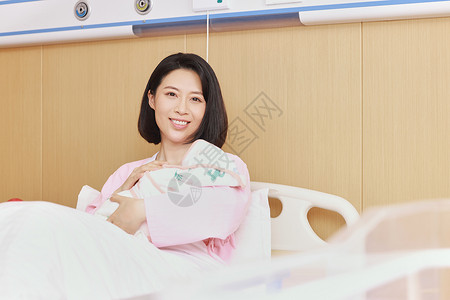 医院病床上妈妈抱着新生儿背景图片