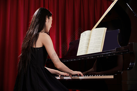美女音乐教师弹奏钢琴背影背景图片