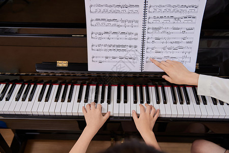 音乐教师教儿童弹奏钢琴特写背景图片