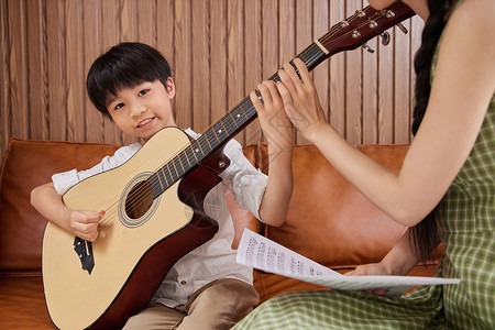 音乐教师教小男孩学生弹吉他女性高清图片素材