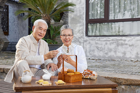 中秋节爷爷奶奶庭院里喝茶背景图片