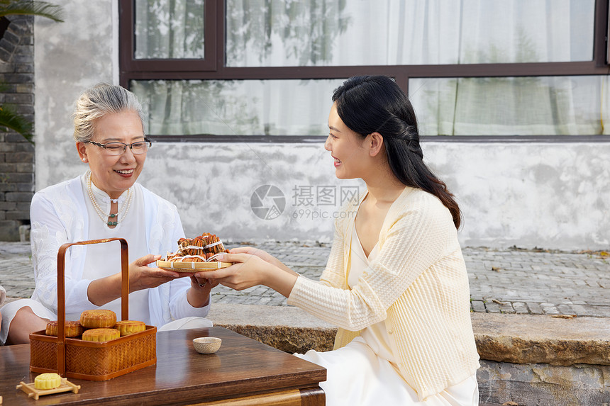 中秋节母女团聚庭院里吃月饼图片