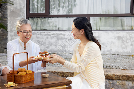 中秋节母女团聚庭院里吃月饼图片