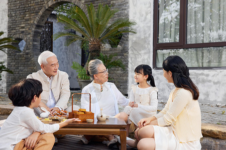 一家人庭院里相聚过中秋节吃月饼图片